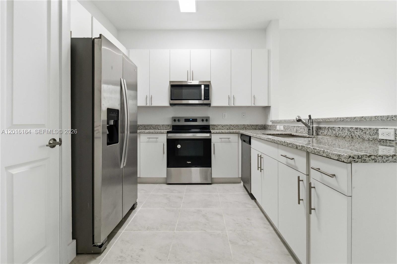 18901 Southwest 316th Street Homestead, FL 33030 - Photo 13 of 33 a kitchen with stainless steel appliances granite countertop a stove a refrigerator and a sink