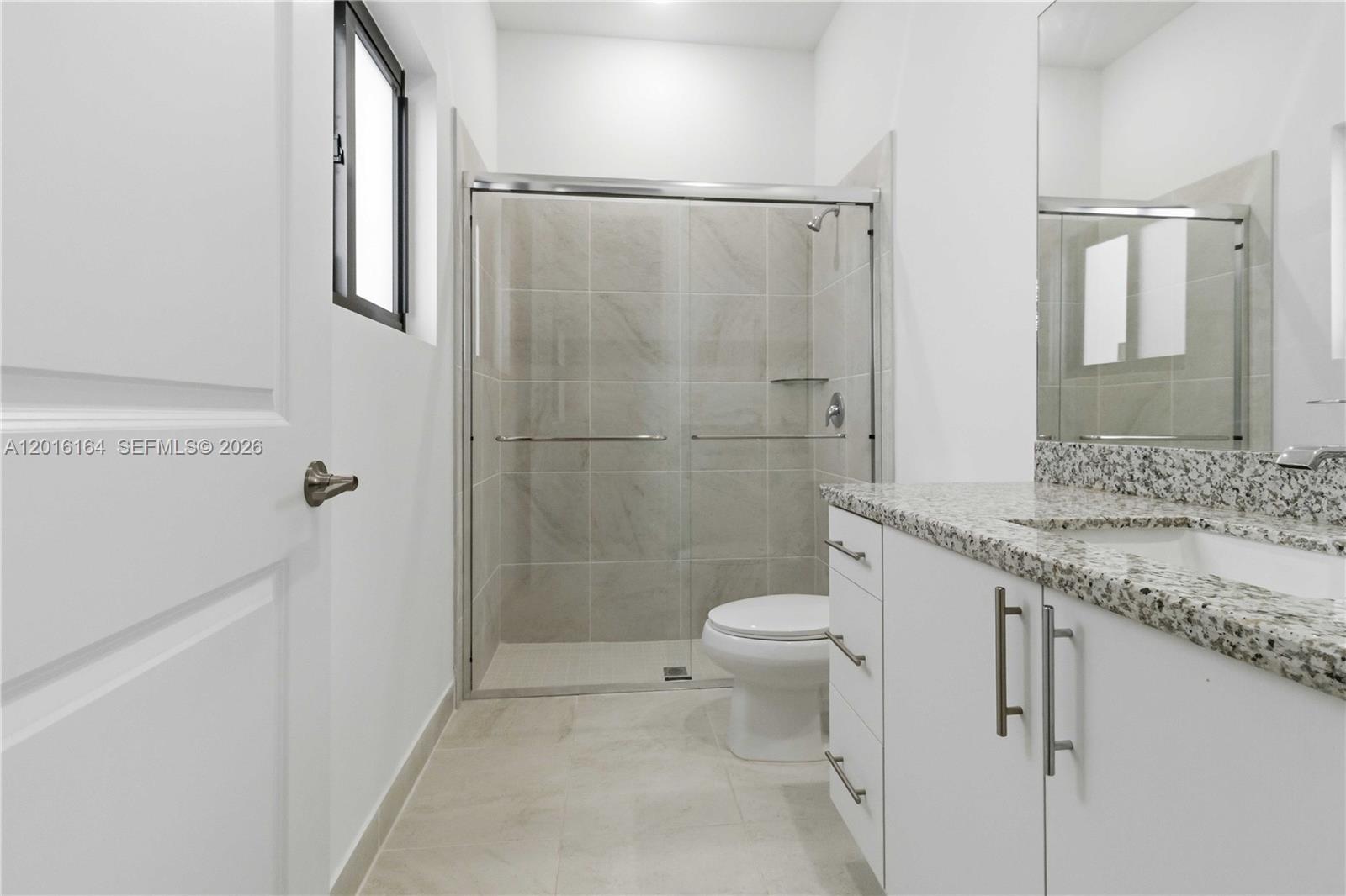 18901 Southwest 316th Street Homestead, FL 33030 - Photo 27 of 33 a bathroom with a granite countertop sink toilet and shower