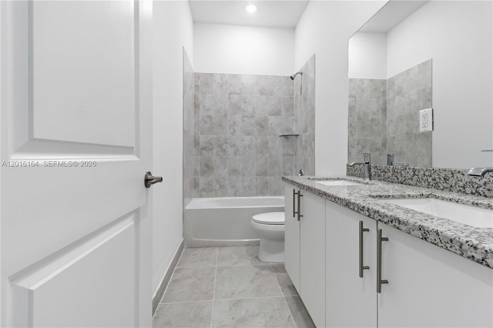 18901 Southwest 316th Street Homestead, FL 33030 - Photo 29 of 33 a bathroom with a granite countertop sink a toilet and bathtub