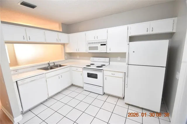 a kitchen with white cabinets and white appliances