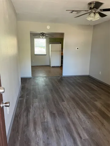 a view of a small space with wooden floor and a window