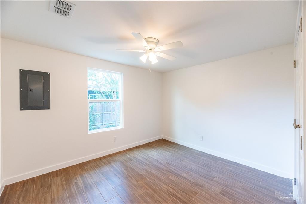 214 South 28th Street McAllen, TX 78501 - Photo 7 of 9 an empty room with wooden floor ceiling fan and windows