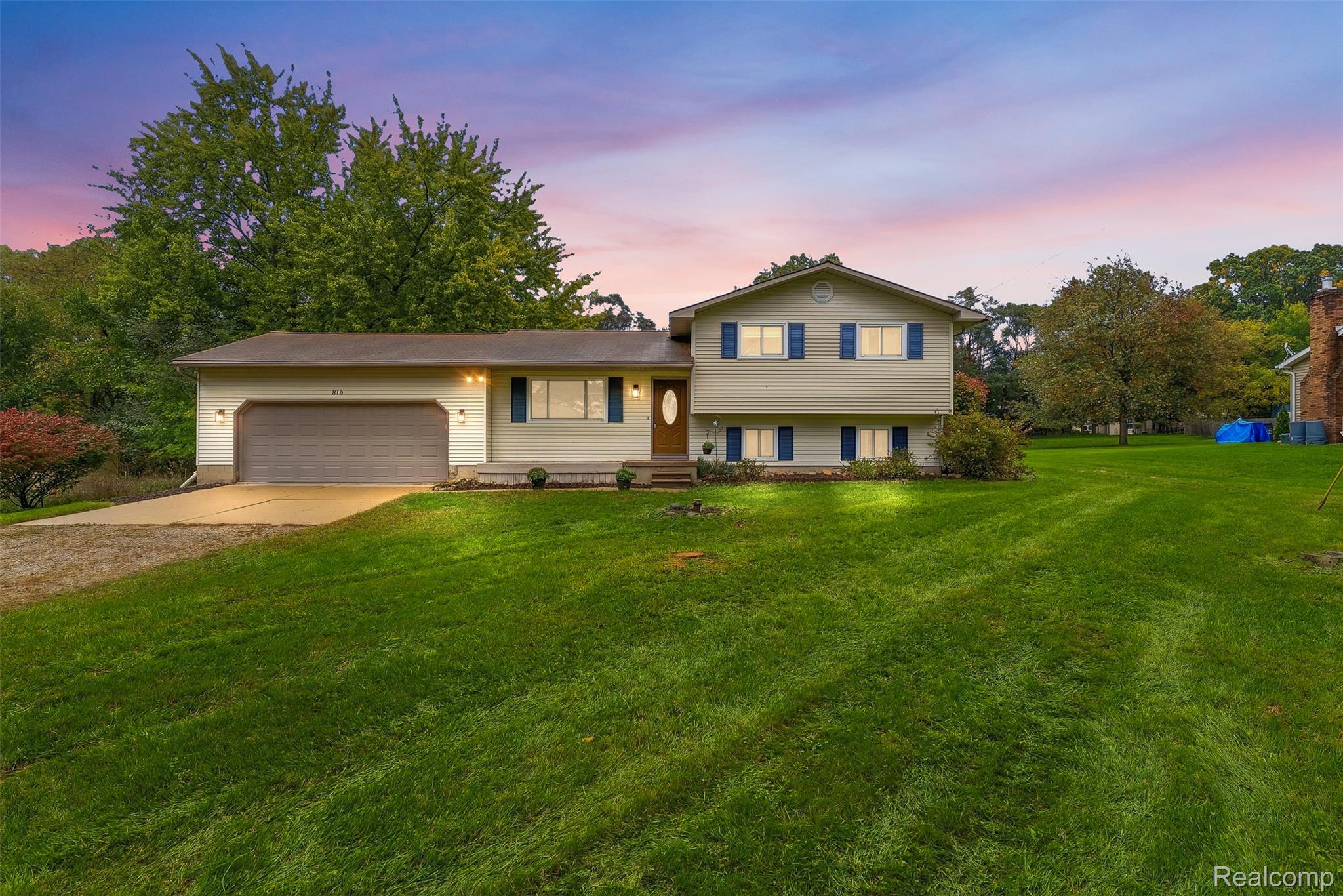 819 Alpine Trail Fenton, MI 48430 - Photo 1 of 41 Split-level residence featuring a two-car garage, concrete driveway, and expansive front lawn