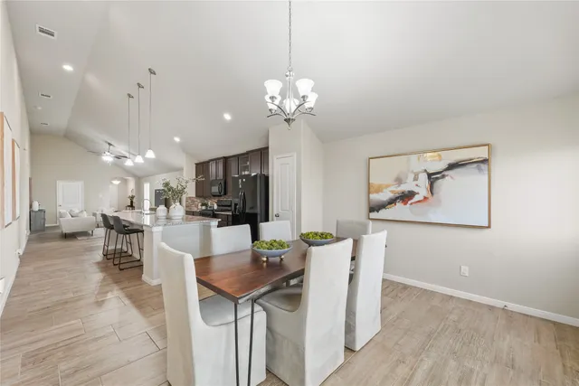 a view of a dining room with furniture and a chandelier