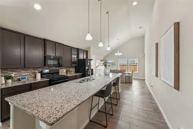 a kitchen with stainless steel appliances granite countertop counter space a sink refrigerator and cabinets