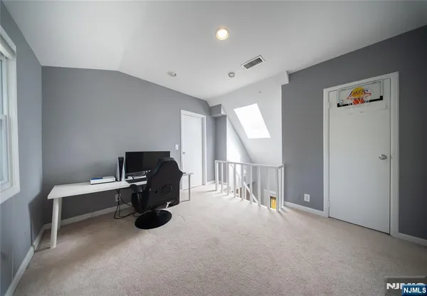 a view of a workspace with furniture and a window