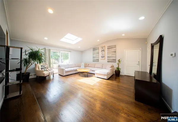 a living room with furniture floor to ceiling window and wooden floor