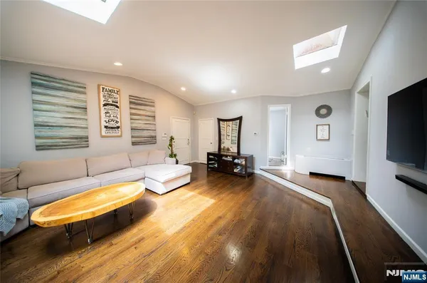 a spacious bedroom with a bed a couch and a flat tv screen on the dresser