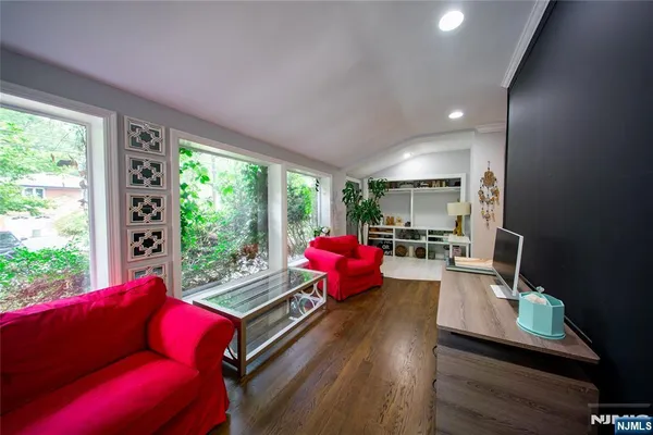 a living room with furniture floor to ceiling window and wooden floor