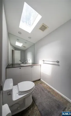 a bathroom with a toilet a sink and mirror