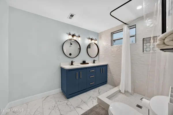 a bathroom with a sink mirror and vanity