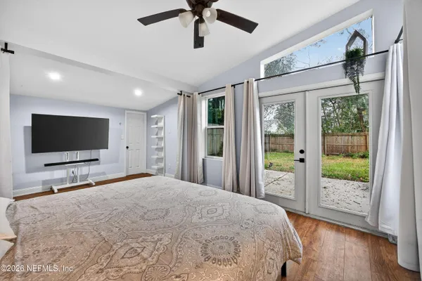 a bedroom with a bed tv and a window