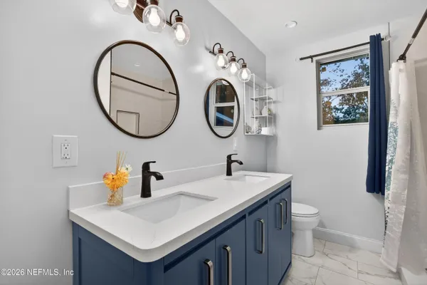 a bathroom with a toilet a sink and a mirror