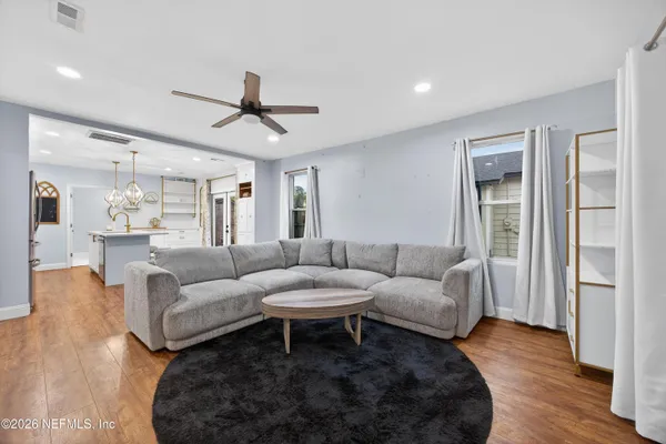 a living room with furniture and a wooden floor