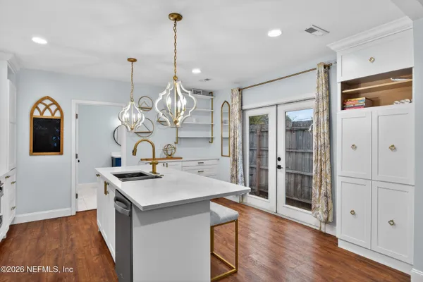 a kitchen with a refrigerator a sink cabinets and wooden floor