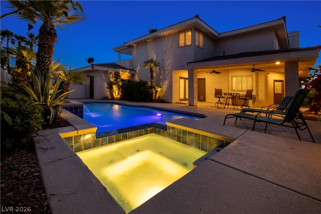 1135 Calico Ridge Drive Henderson, NV 89011 - Photo 73 of 86 An illuminated pool and spa at dusk offer a tranquil backyard escape.