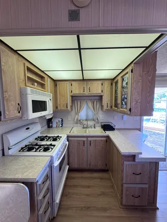 a kitchen with stainless steel appliances granite countertop a sink a stove top oven a counter space and cabinets