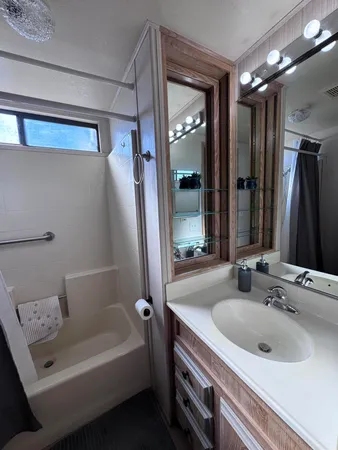 a bathroom with a tub a sink and mirror