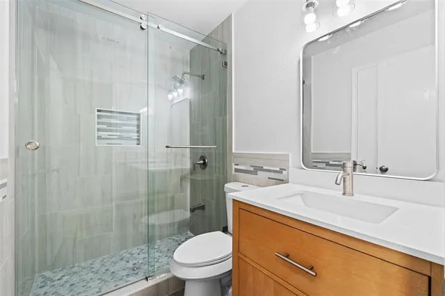 a bathroom with a sink a toilet and shower