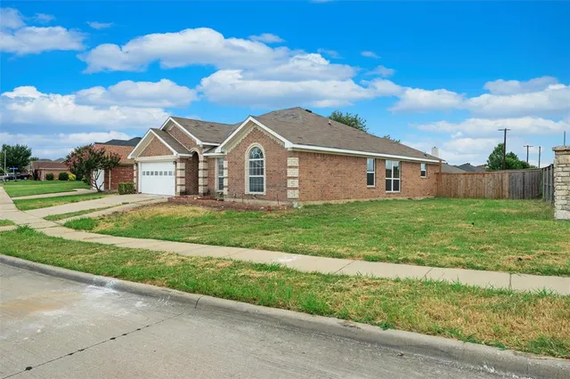 a front view of a house with a garden and yard