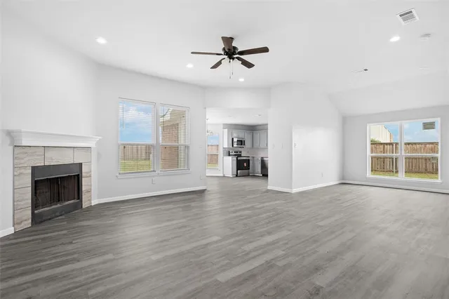 a view of an empty room with a window and fireplace