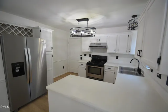 a kitchen with stainless steel appliances a refrigerator sink and stove