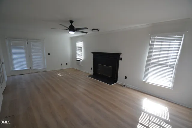 an empty room with a fireplace and windows