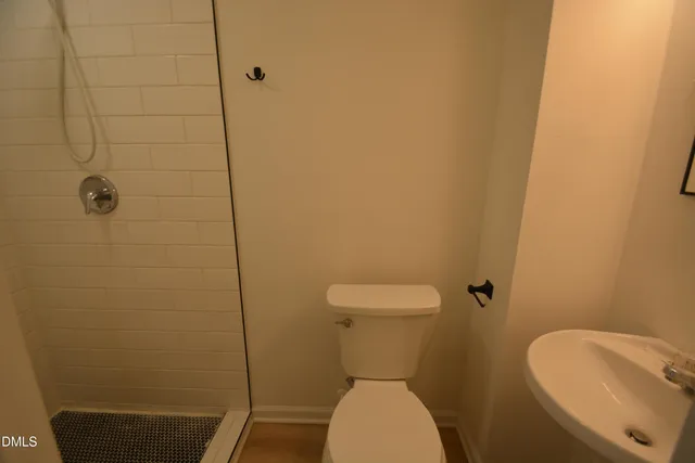 a white toilet sitting next to a bathroom sink and a shower