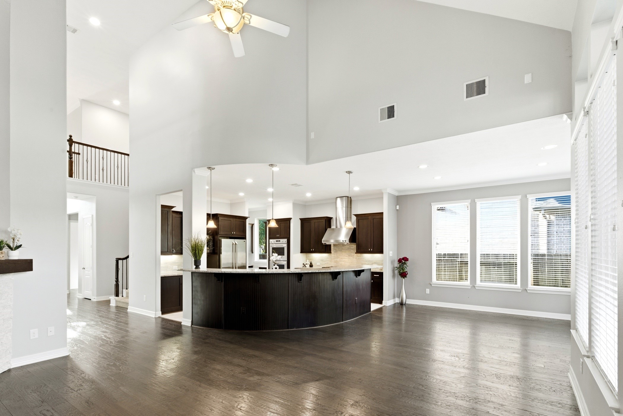 27834 Hunters Rock Lane Katy, TX 77494 - Photo 19 of 46 a view of a living room and kitchen with furniture wooden floor and windows