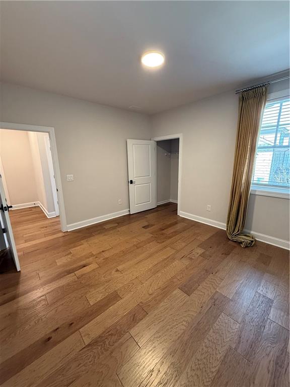 419 Duncan Dene Drive, Unit 140 Alpharetta, GA 30022 - Photo 11 of 22 an empty room with wooden floor and windows