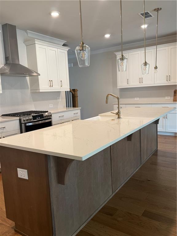 419 Duncan Dene Drive, Unit 140 Alpharetta, GA 30022 - Photo 5 of 22 a kitchen with kitchen island a sink dishwasher a stove and white cabinets with wooden floor