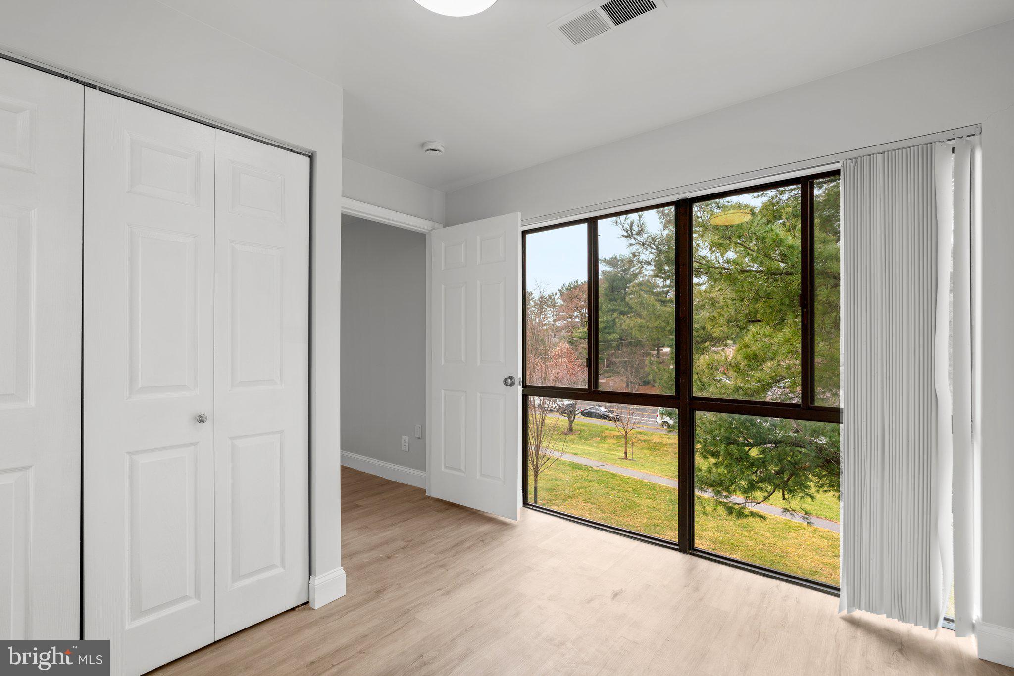 19048 Mills Choice Road, Unit 19048 Gaithersburg, MD 20886 - Photo 16 of 40 a view of a room with wooden floor and doors