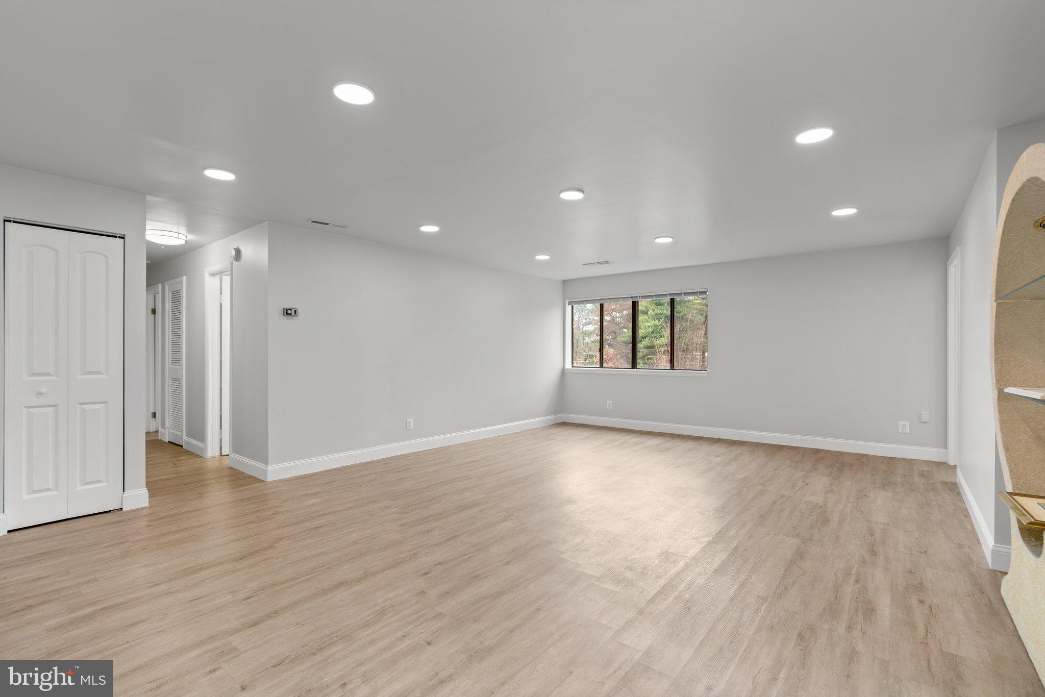 19048 Mills Choice Road, Unit 19048 Gaithersburg, MD 20886 - Photo 6 of 40 a view of an empty room with wooden floor and a window