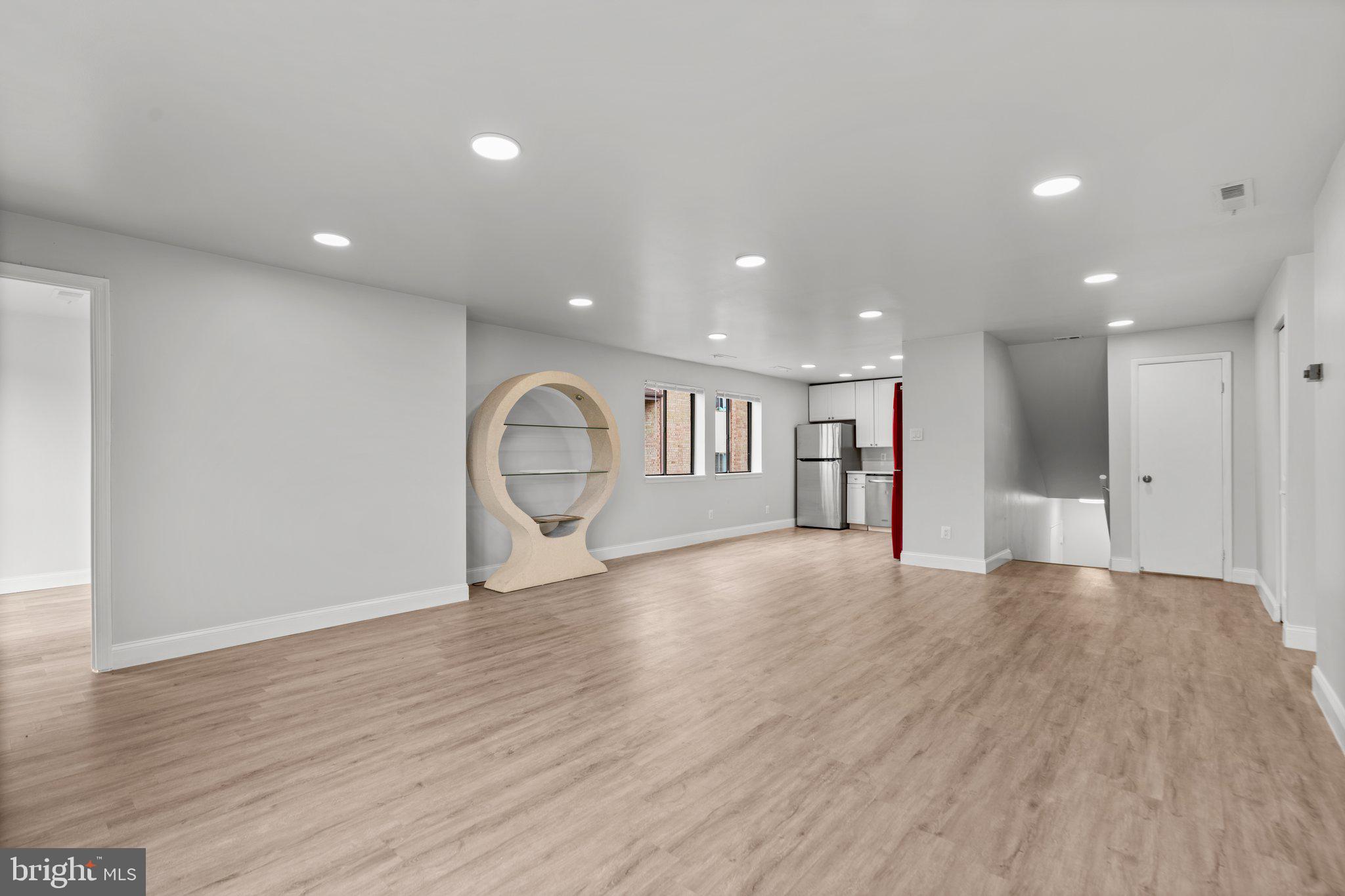 19048 Mills Choice Road, Unit 19048 Gaithersburg, MD 20886 - Photo 8 of 40 a view of an empty room with wooden floor and windows