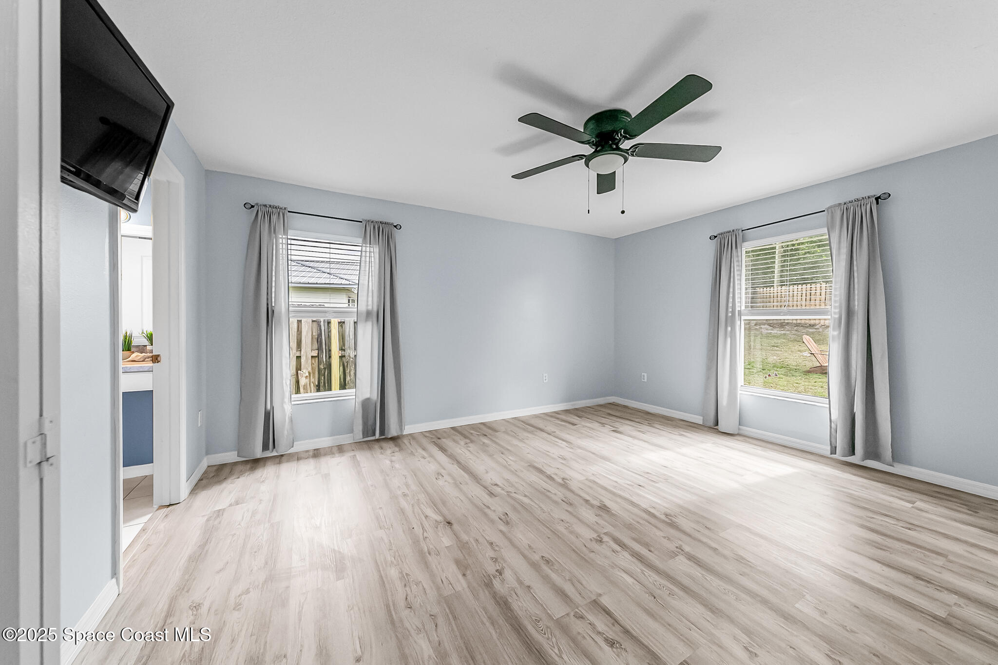 233 Broadview Drive Cocoa, FL 32922 - Photo 19 of 44 a view of an empty room with a window and wooden floor