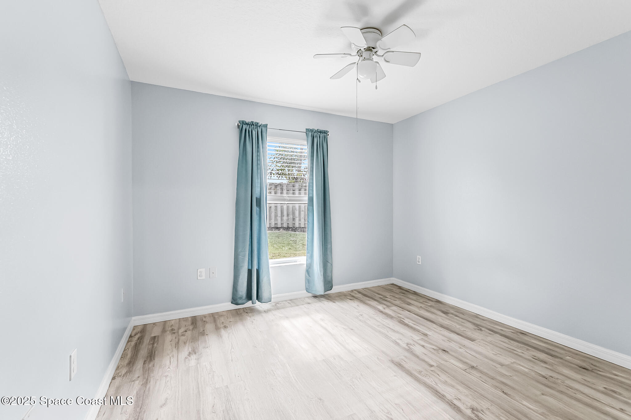 233 Broadview Drive Cocoa, FL 32922 - Photo 24 of 44 an empty room with a chandelier fan and windows