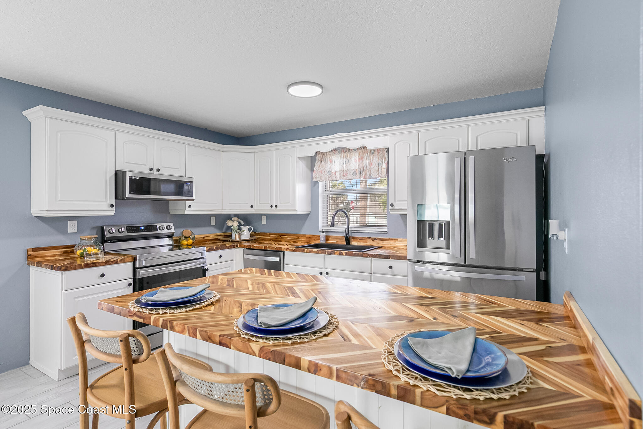 233 Broadview Drive Cocoa, FL 32922 - Photo 7 of 44 a kitchen with sink a stove and chairs