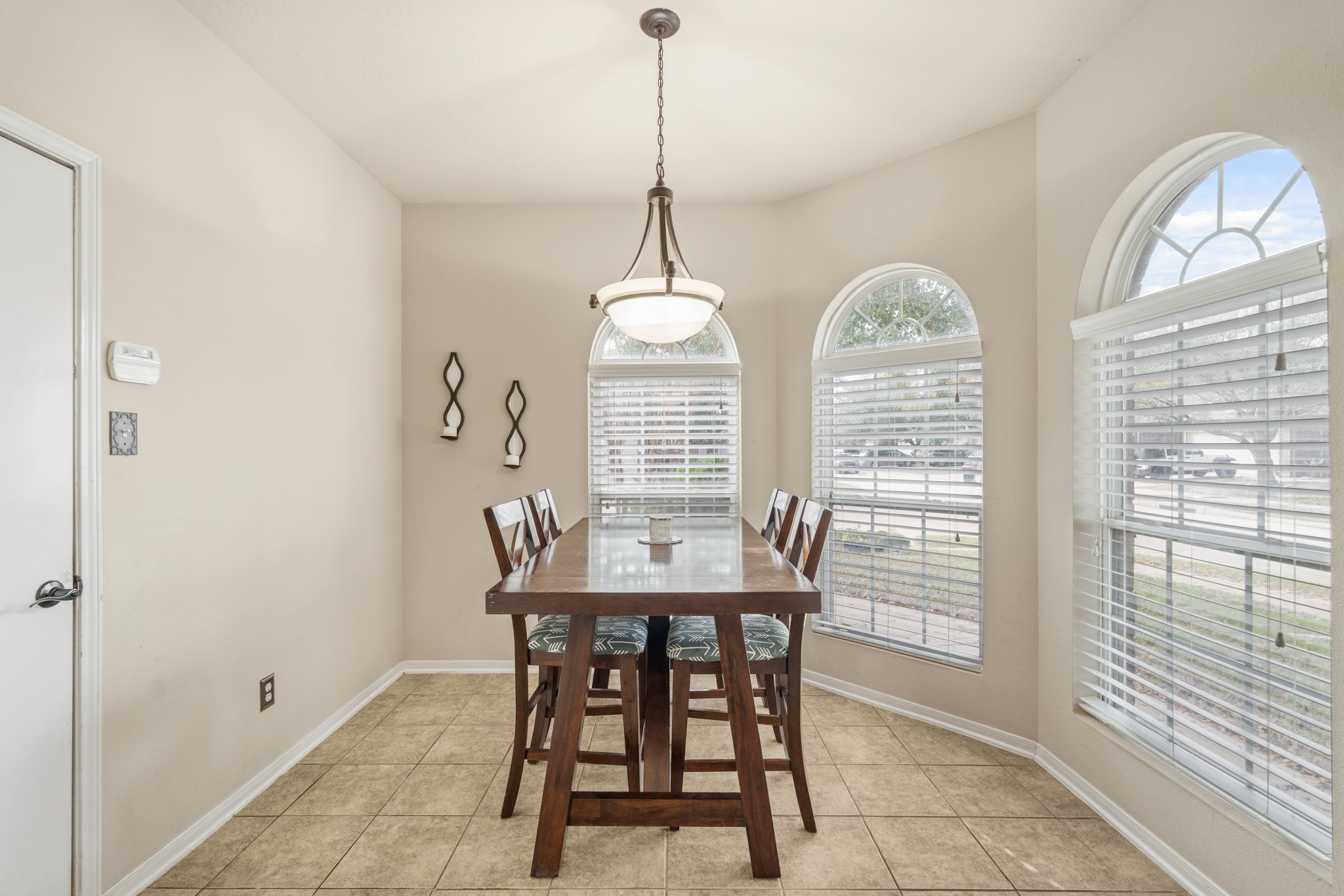 19646 Hardwood Ridge Trail Cypress, TX 77429 - Photo 11 of 22 This dining area is bright and inviting, designed to feel open and comfortable for everyday meals or gatherings. Three arched windows with white blinds line the wall, allowing sunlight to pour in while still offering privacy.