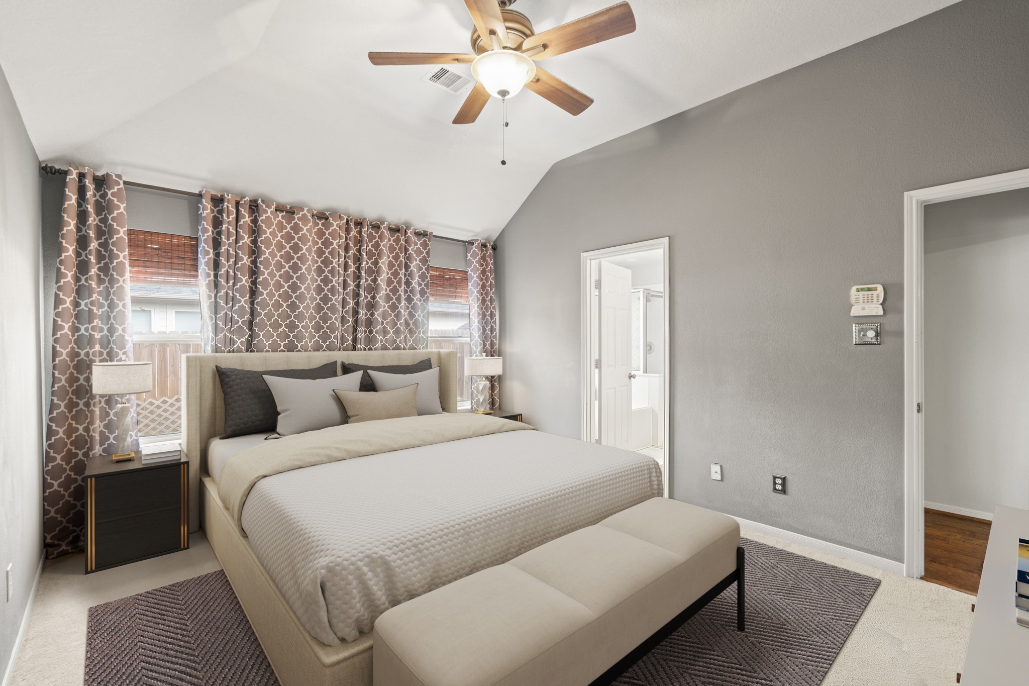 19646 Hardwood Ridge Trail Cypress, TX 77429 - Photo 12 of 22 Virtually Staged: This primary bedroom is spacious and serene, offering a comfortable retreat with a soft, modern aesthetic. The room features neutral gray walls and carpet flooring, creating a calm and inviting atmosphere. A vaulted ceiling enhances the sense of space, while a ceiling fan with light adds both style and functionality.