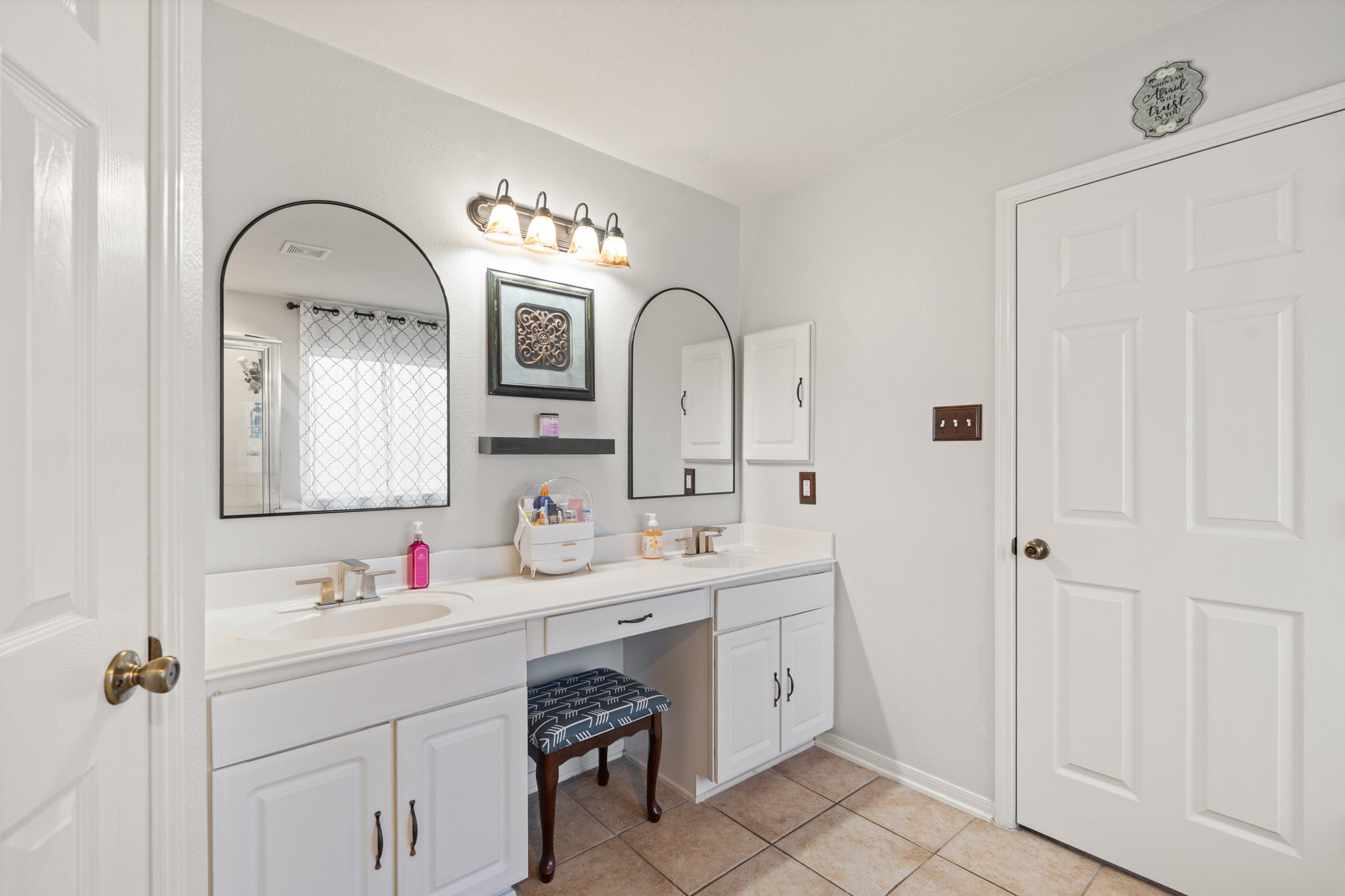 19646 Hardwood Ridge Trail Cypress, TX 77429 - Photo 16 of 22 It features separate sinks, large arched framed mirrors, vanity area, and beautiful wood cabinets.