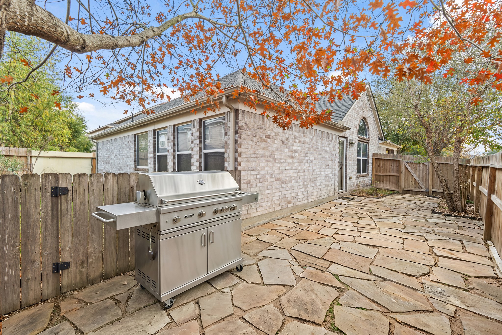 19646 Hardwood Ridge Trail Cypress, TX 77429 - Photo 22 of 22 Virtually Cleaned: This backyard offers a charming, private setting that’s well suited for outdoor entertaining and barbecues. A stone-paved patio runs alongside the home, providing a solid surface for placing a grill, outdoor table, or seating area.