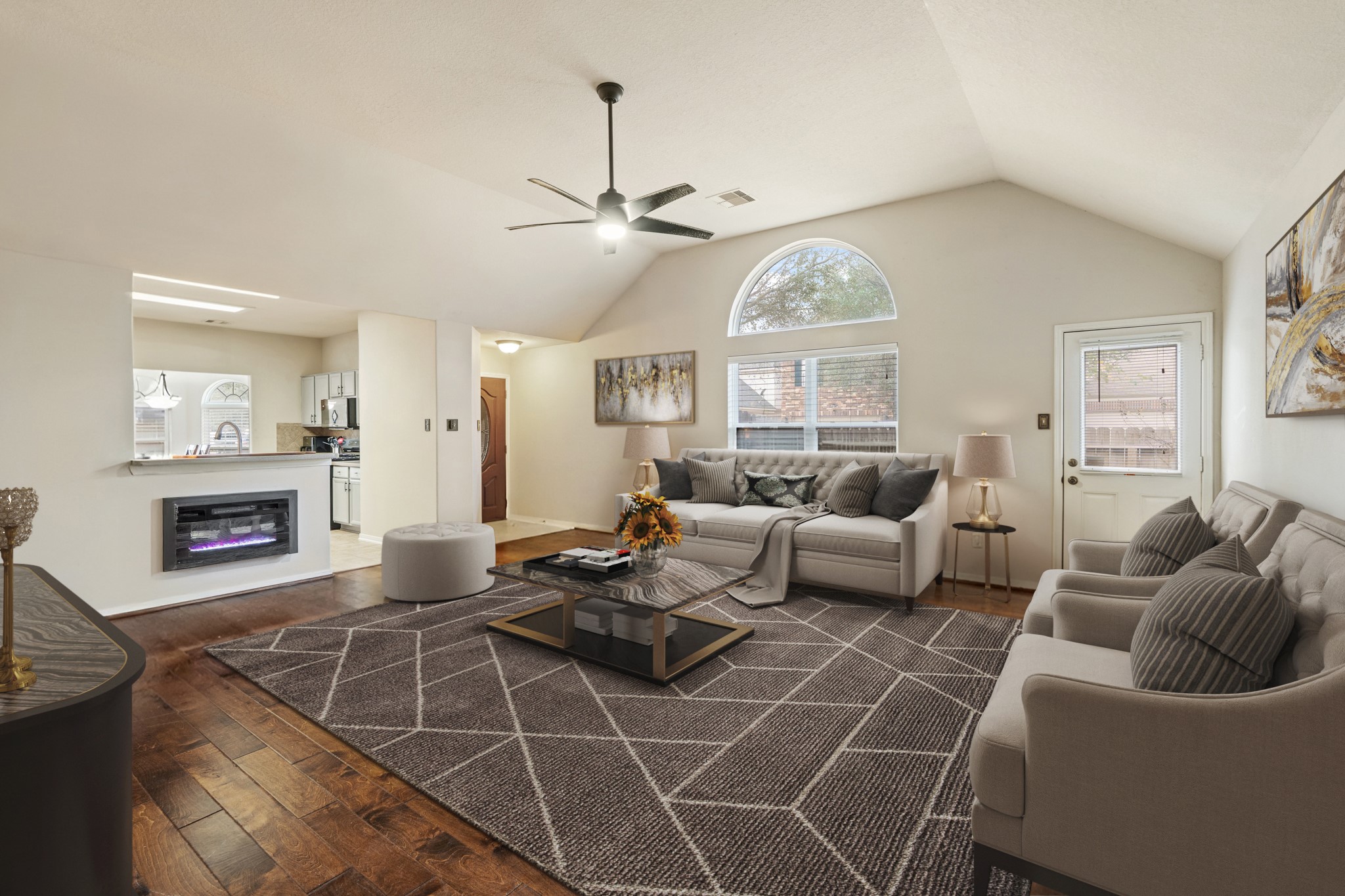 19646 Hardwood Ridge Trail Cypress, TX 77429 - Photo 6 of 22 Virtually Staged: The room is anchored by a cozy seating creating a welcoming gathering area. The open layout flows seamlessly into the kitchen, where a built-in fireplace adds a unique architectural touch.