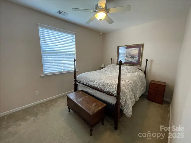 a bed sitting in a bedroom next to a window