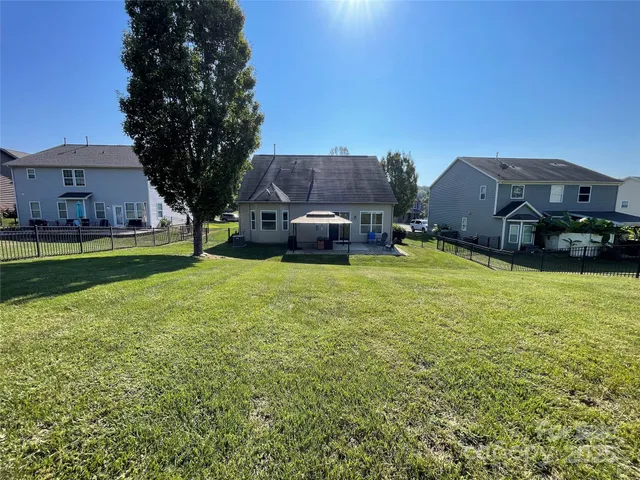 a aerial view of a house with a yard and large trees
