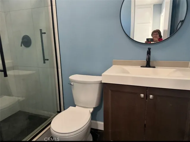 a view of an empty room with wooden floor and a ceiling fan