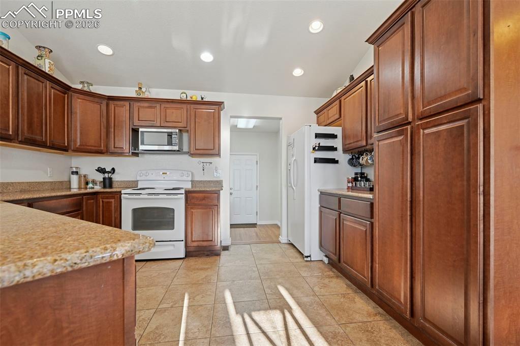 16575 Cathys Loop Peyton, CO 80831 - Photo 13 of 49 a kitchen with stainless steel appliances granite countertop a refrigerator sink and cabinets