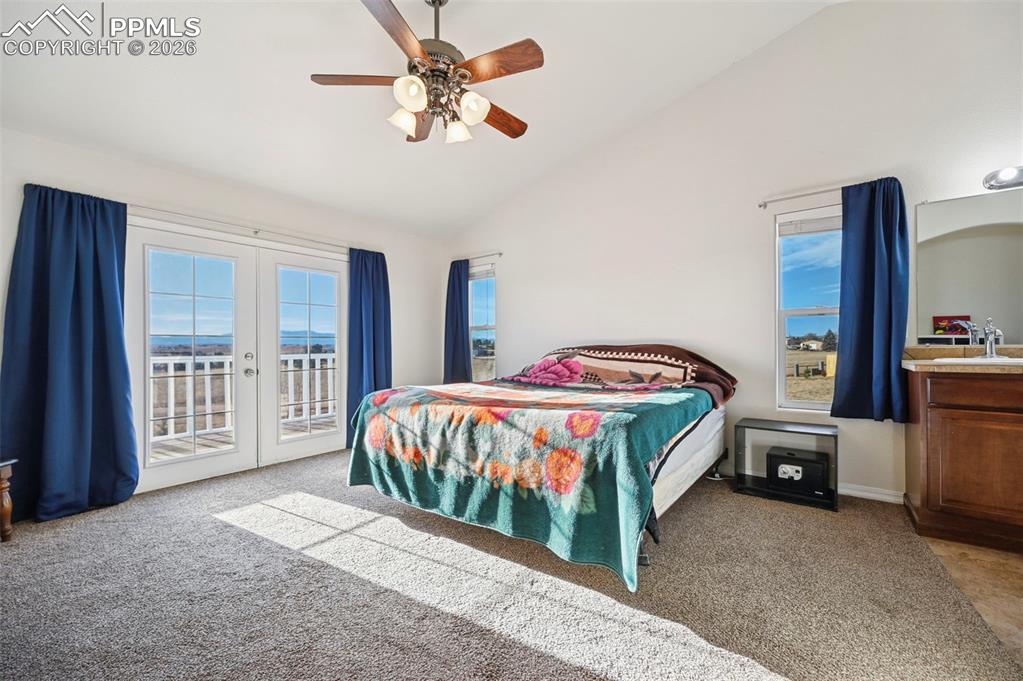16575 Cathys Loop Peyton, CO 80831 - Photo 16 of 49 a bedroom with a large bed and a chandelier