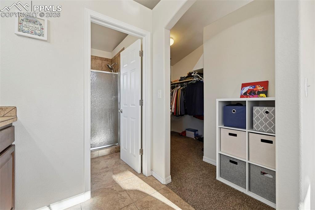 16575 Cathys Loop Peyton, CO 80831 - Photo 19 of 49 a view of walk in closet with clothes and shoes