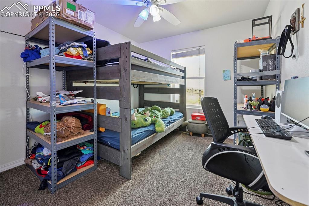 16575 Cathys Loop Peyton, CO 80831 - Photo 28 of 49 a bedroom with a bed and a chandelier