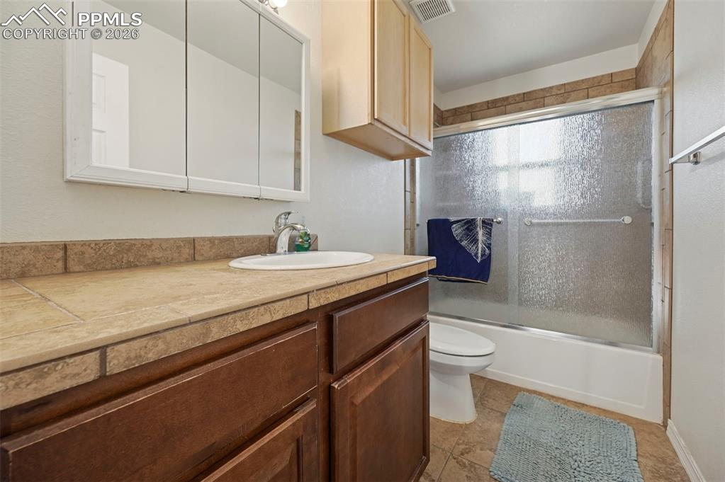 16575 Cathys Loop Peyton, CO 80831 - Photo 28 of 49 a bathroom with a granite countertop sink a toilet and shower